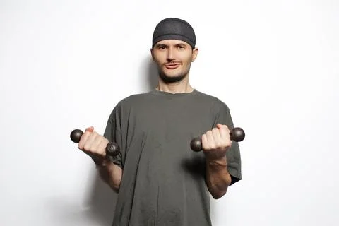 Young man doing gym with two small dumbbells isolated on white background. .. Stock Photos