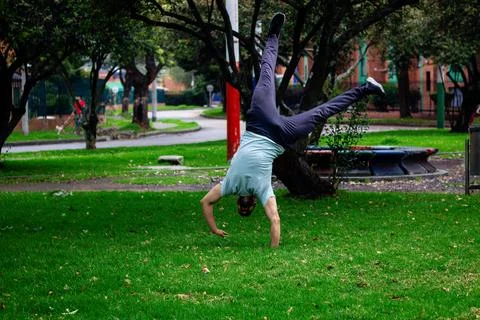 Young man doing half moon break dance acrobatics in a park in the city Stock Photos