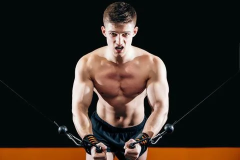 Young man doing hand-cutting on the simulator in the gym. Stock Photos