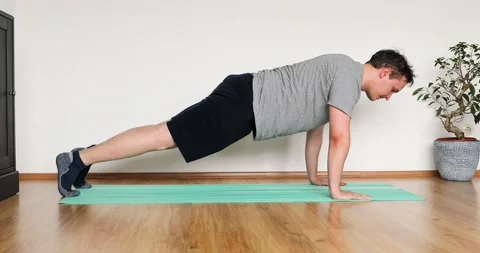 Young man doing her workout at home - pushup exercise Stock Footage 131314131