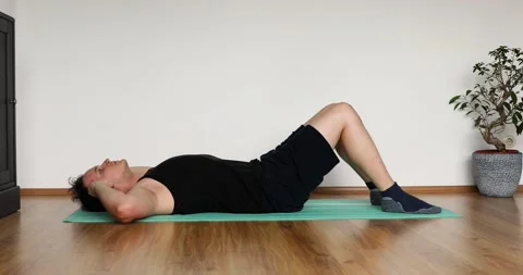 Young man doing her workout at home - crunch exercise Stock Footage 131314157