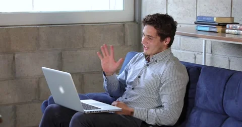 Young man doing home work with his laptop Stock Footage 136065365