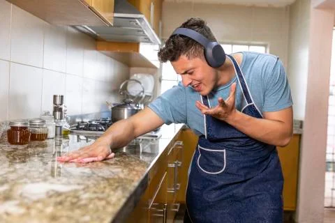 Young man doing housework singing Stock Photos