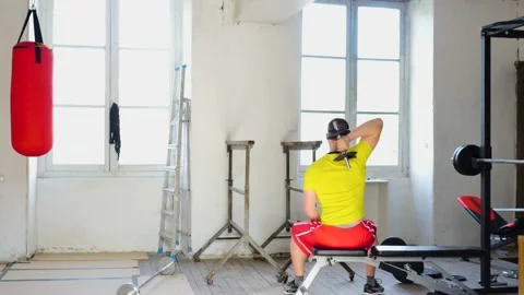 Young Man Doing indoor musculation. Man Doing triceps extensions in home gym. Stock Footage 153784043