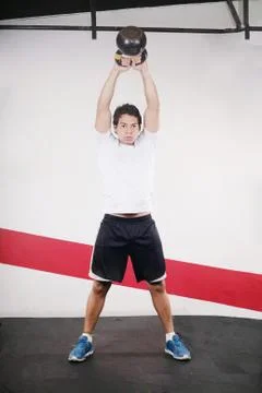 Young man doing kettlebell workout on gym Stock Photos