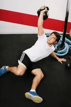 Young man doing kettlebell workout on gym Stock Photos
