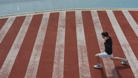 Young man doing lunges Stock Footage 100029522