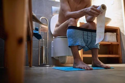 A young man doing morning needs at the home toilet. Man, home, toilet, needs Stock Photos