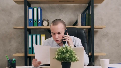 Young man doing paperwork in office Stock Footage 104902450