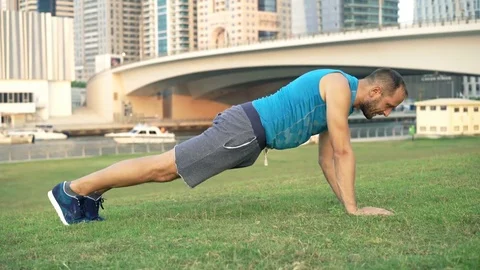 Young man doing plank exercise on the grass in the city, 4K Vídeo Stock 72039638