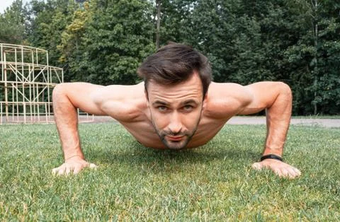 Young man doing press ups on the grass Stock Photos