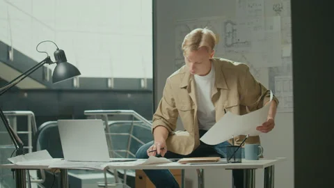 Young Man Doing Project Sitting on the Chair Indoors Sketching Plan Making Notes Video stock 239102629