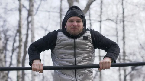 Young man doing pull up exercise on winter training on sport ground close up 動画素材 87999080