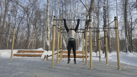 Young man doing pull up exercise on crossbar during winter gym workout Stock Footage 89277309