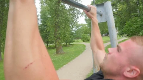 Young man doing pull-ups during crossfit workout at the park. Slow motion Stock Footage 84003073