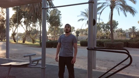 Young man doing pull ups on horizontal bar Stock Footage 121941514