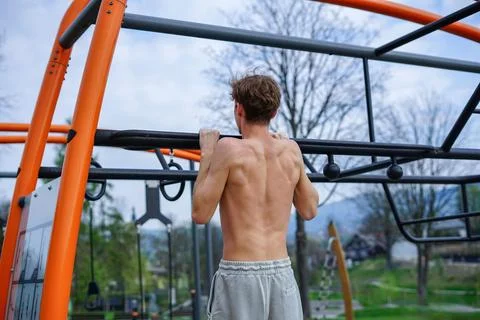 Young Man doing pull-ups outdoors Stock Photos