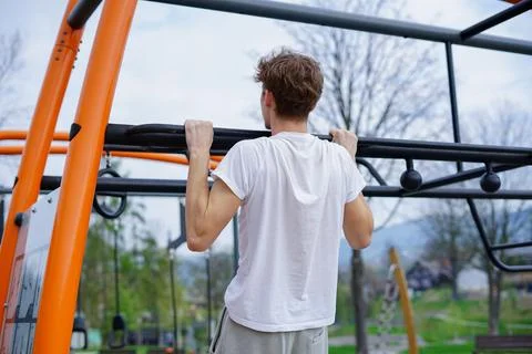 Young Man doing pull-ups outdoors Stock Photos
