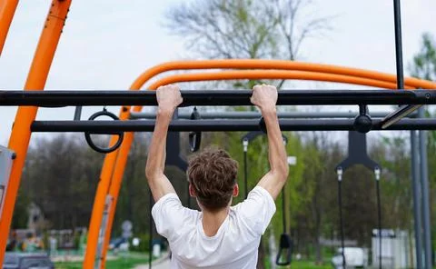 Young Man doing pull-ups outdoors Stock Photos