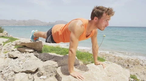 Young Man Doing Push Ups On Rocks By Ocean Stock Footage 49946283