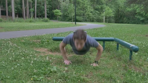 A young man doing push ups and exercising outside Stock Footage 75846410