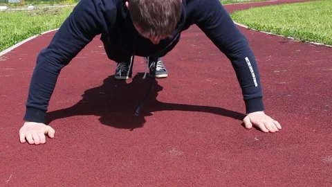 A young man is doing push-UPS on the street from a treadmill Stock Footage 131654063