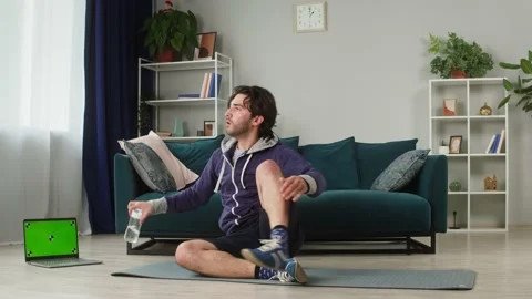 Young man doing push-ups from the floor in living room, using video fitness Stock Footage 157369437