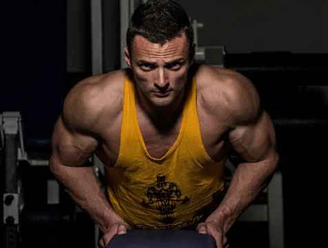 Young man doing push ups in gym Stock Photos