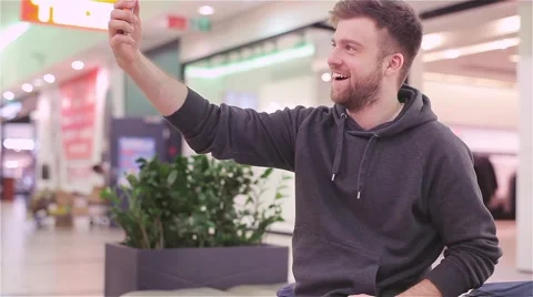 Young Man Doing Selfie and Send to Phone in the Mall. Stock Footage 47977368