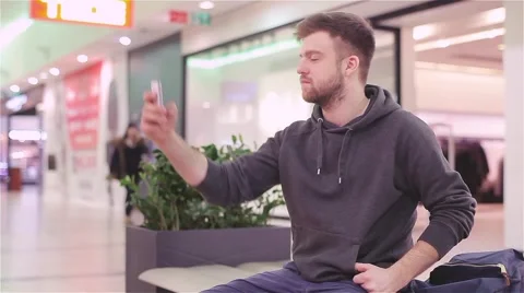 Young Man Doing Selfie and Send to Phone in the Mall. Video stock 47977391