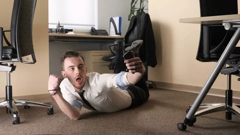 Young man doing selfie lying on the floor in the middle of the office. 60 fps Video stock 83684026