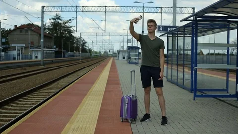 Young man doing selfies on the train station while waiting for arrival Video stock 78655878