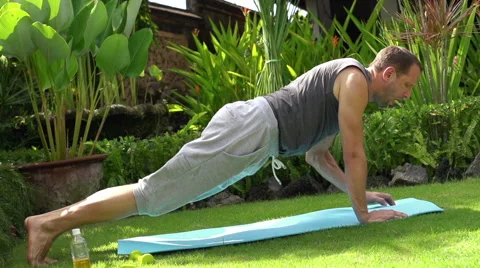 Young man doing sit-ups with dumbbell in the garden super slow motion 240fps HD Видео 39966496