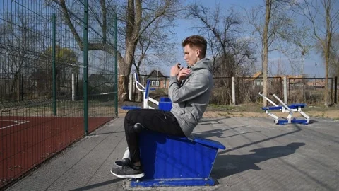 Young man doing sit-ups on bars outdoors. Stock-Footage 131142781