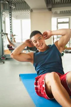 Young man doing sit-ups in the gym Foto stock