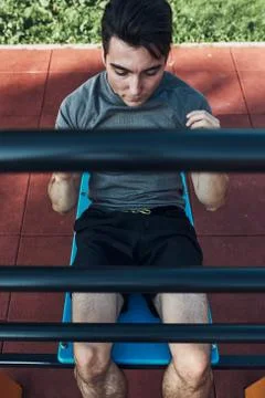 Young man doing sit-ups during his workout in a modern calisthenics street wo Stock Photos