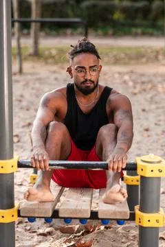 Young man doing sit-ups during workout in a calisthenics street workout park Stock Photos