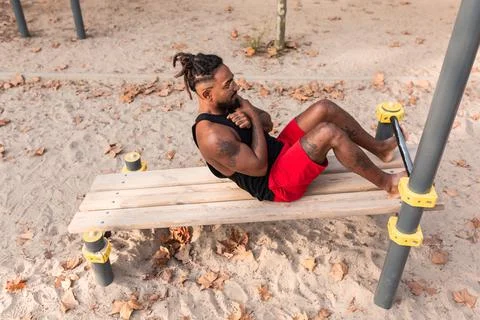 Young man doing sit-ups during workout in a calisthenics street workout park Stock Photos