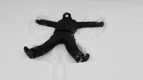 Young man doing snow angels Stock Footage 47454644