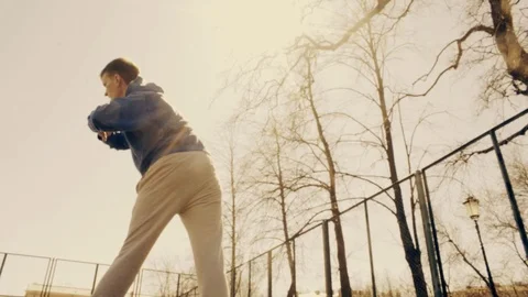 Young man doing sports exercises. Training at city athletic field. Sunny day Stock Footage