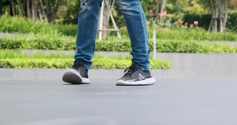Young man doing street dancing with green trees and garden in background, focus Stock Footage 106374723