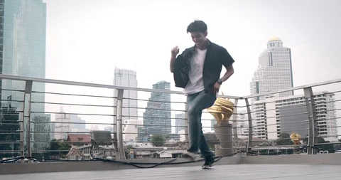 Young man doing street dancing in front of pier in background. Asian man. Stock Footage 106374864