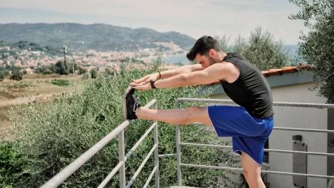 Young man doing stretching exercise outdoor Stock Photos