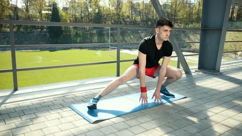 A Young Man Doing Stretching On A Mat In The Open Air Near The Stadium. He Does 스톡 동영상 108405022