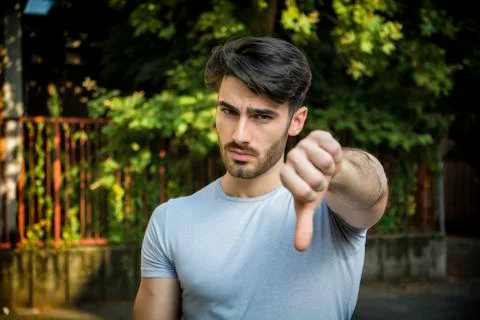 Young man doing thumb down sign with hand Stock Photos