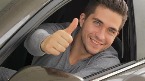 Young man doing thumps-up in car Stock Footage 55244847
