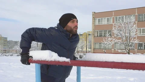 Young man doing triceps dip on parallel bars outdoors in winter slow motion Stock-Footage 96479860