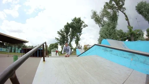 Young man doing a trick on a skateboard in a skate park Stock Footage 69789318