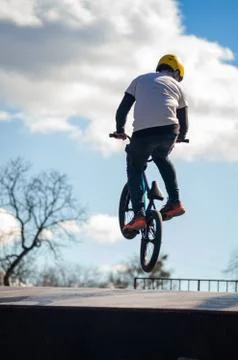 Young man doing tricks on a BMX bike. BMX freestyle against the backdrop of u Stock Photos
