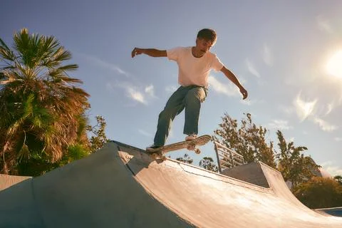 A young man doing tricks on his skateboard at the skate park. Active sport Stock Photos